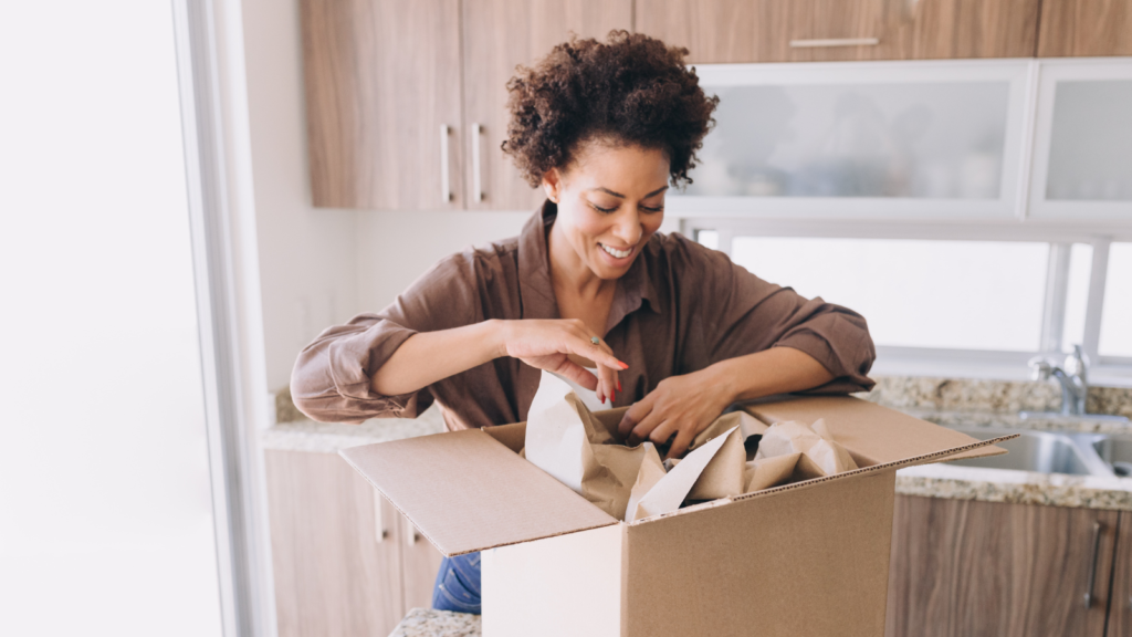 Woman packing a box after selling her home in Raleigh, NC.